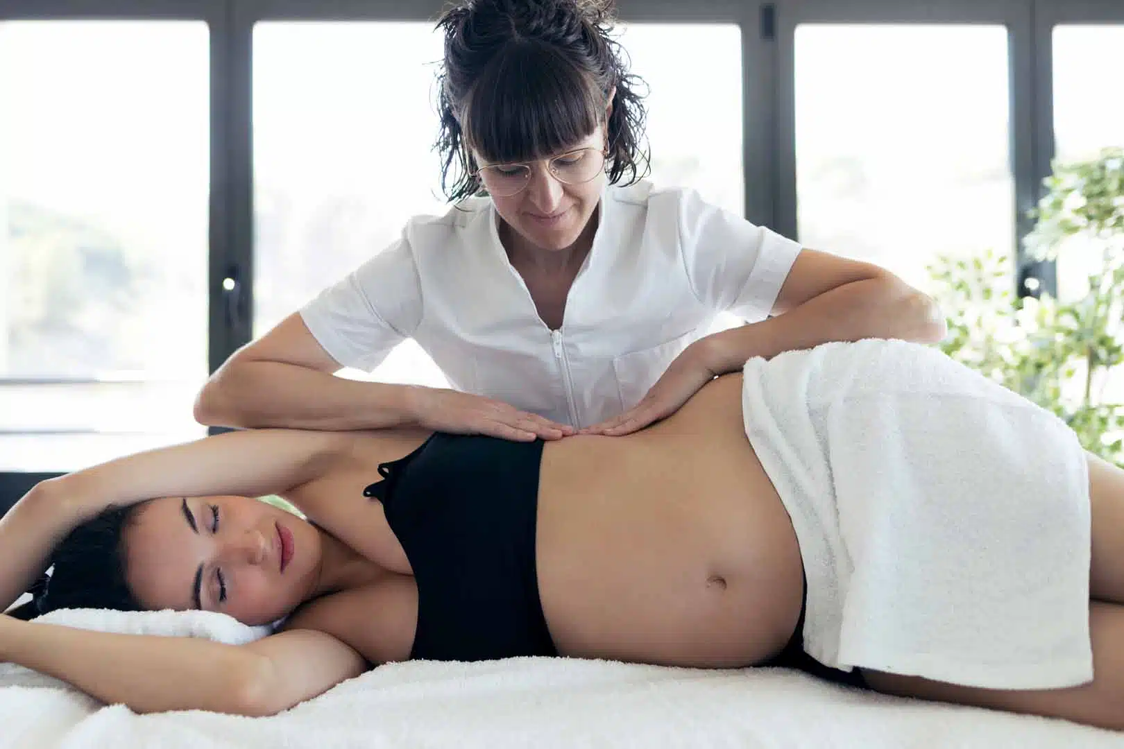 Shot of physiotherapist doing belly massage to pregnant patient
