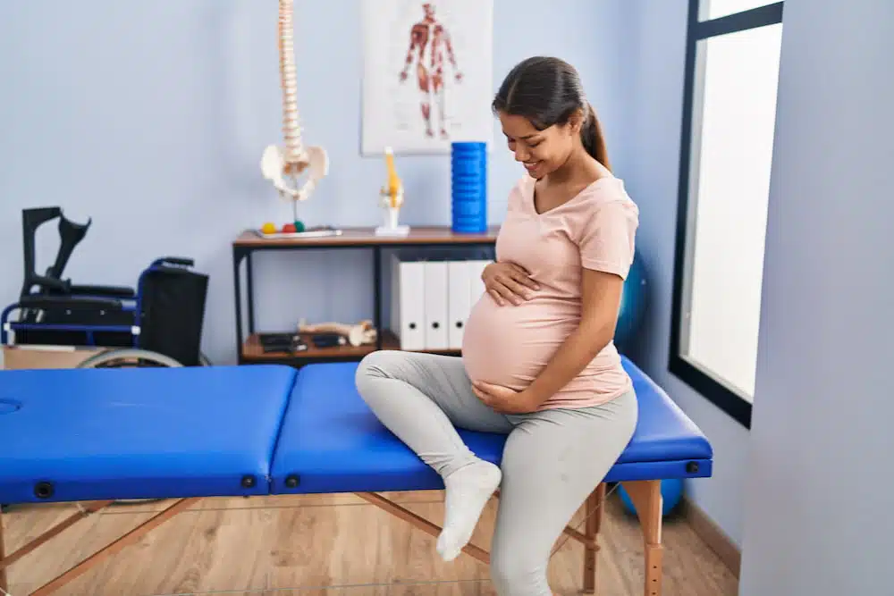 Pregnant woman in a chiropractic clinic to receive a prenatal care from the chiropractor