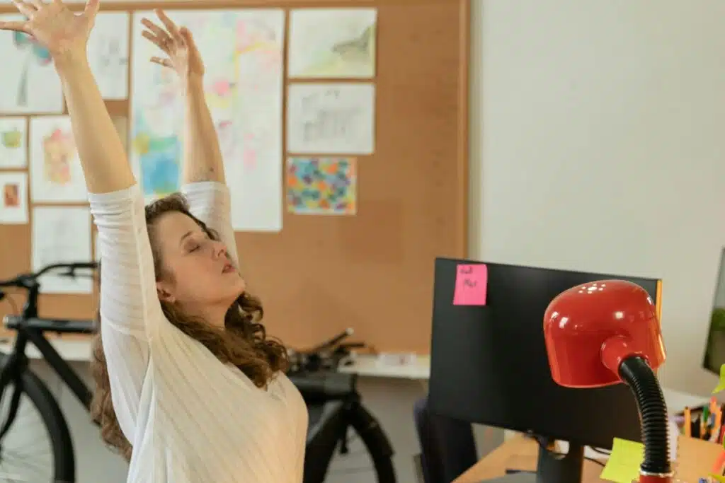 A woman having a stretching while working on a desk