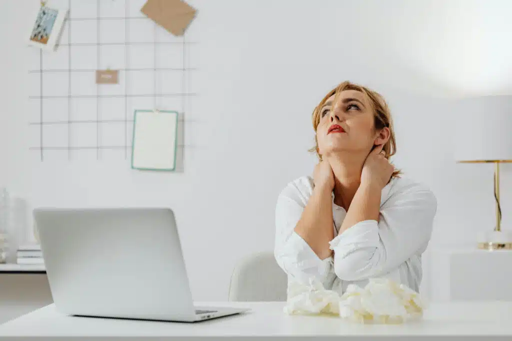 Woman in White Long Sleeve Shirt Sitting at a Table Looking Up