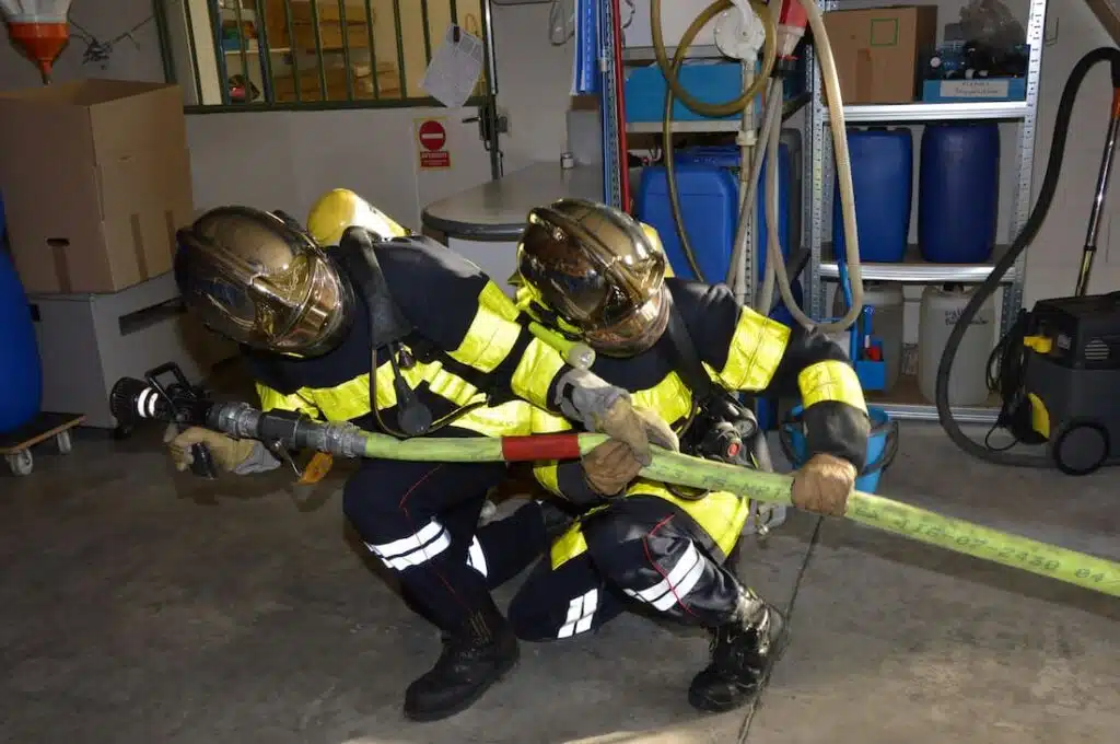 Photo of Two Firefighters Pulling a Fire Hose getting ready for a rescue
